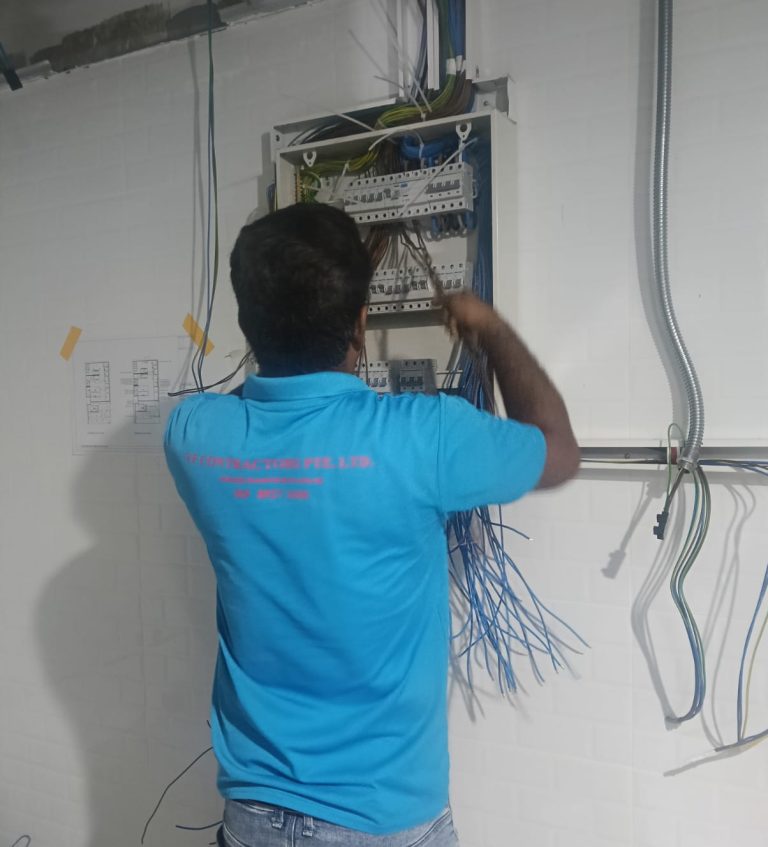 Electrician connecting cables at a distribution board